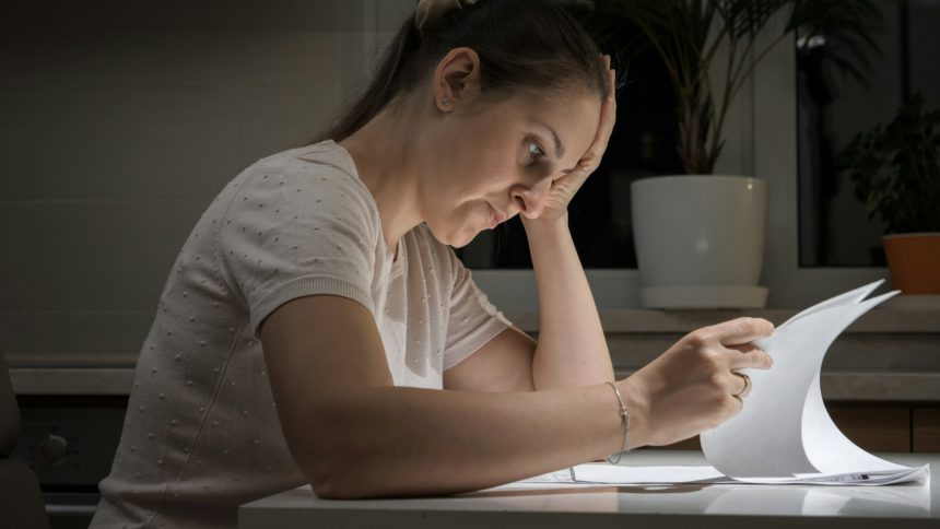 Portrait of stessed woman feeling frustrated while reading documents of divorce. Concept of