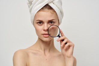 pretty woman with magnifying glass near face acne acne skin care appearance